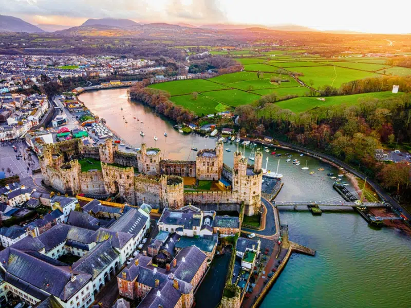 Aerial view of a medieval stone castle by a river and town