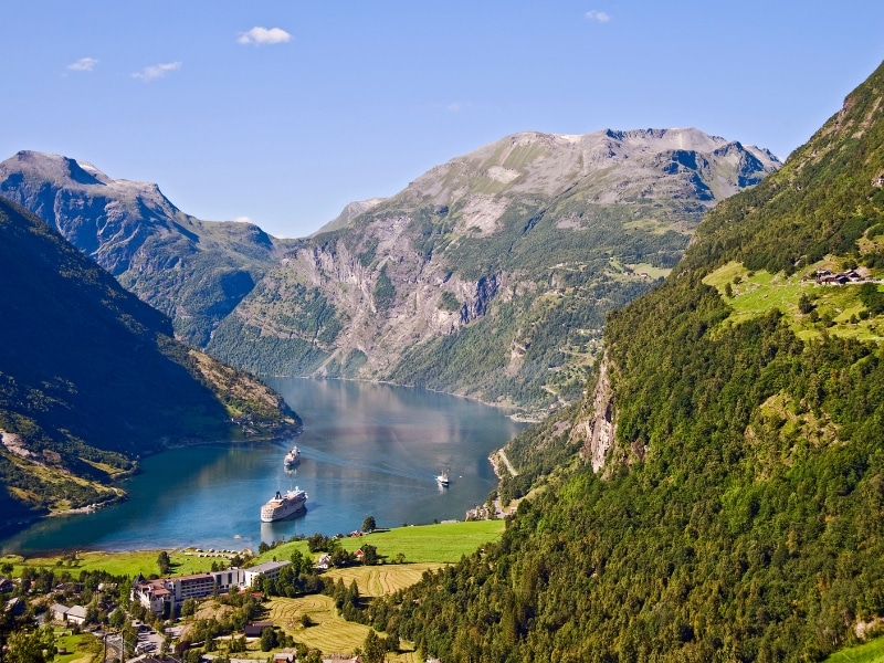 large Norwegian fjord with steep walls and cruise liners on the water