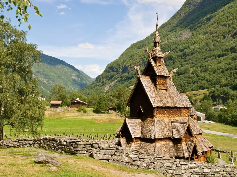 Wooden stave church in. agrassy meadow in Norway