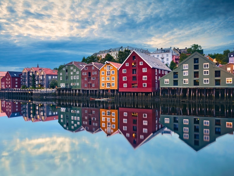 colorful wooden houses  with pitched roofs mirrored in a calm river