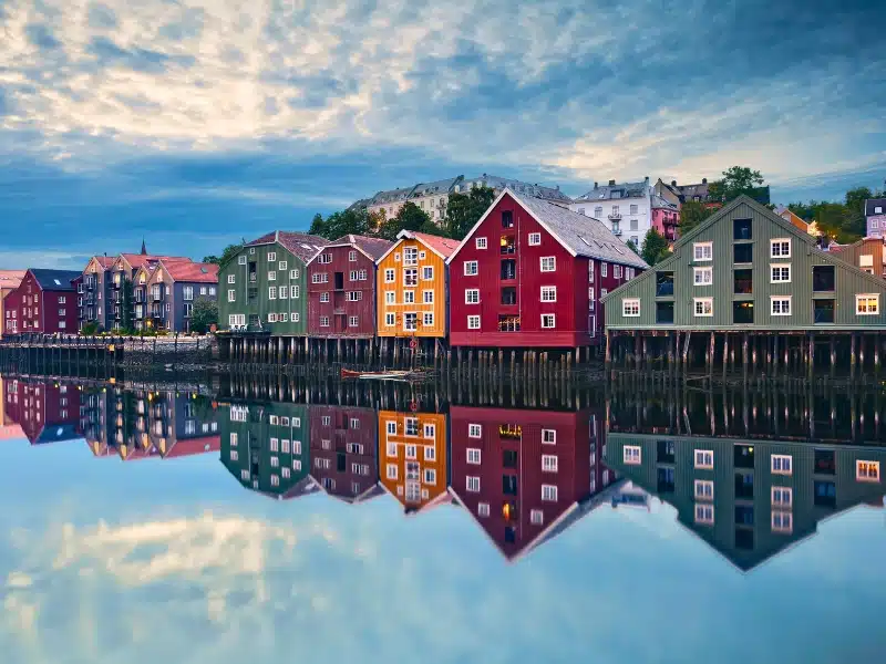colorful wooden houses  with pitched roofs mirrored in a calm river