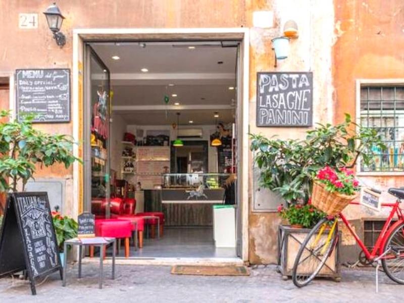 small car in Rome with bicycle and chalkboard outside