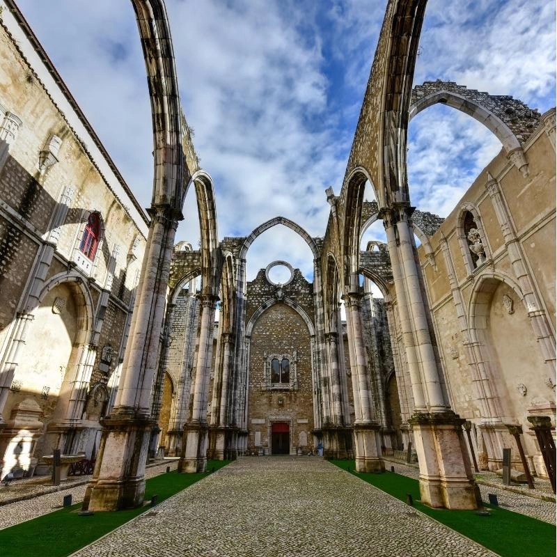 Inside of a ruined church with arches open to a blue sky