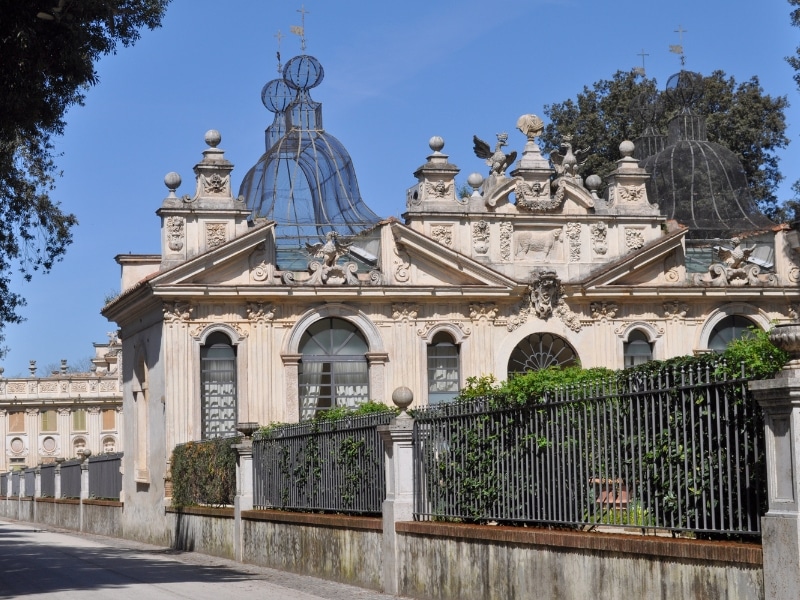 elegant cream stone buildings with arched windows on a road with iron railings