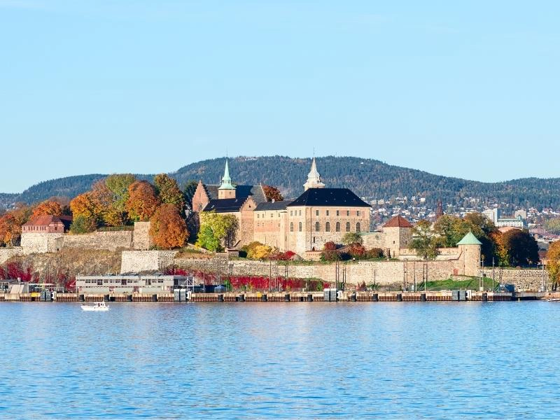 view across blue water to a palace and fortress