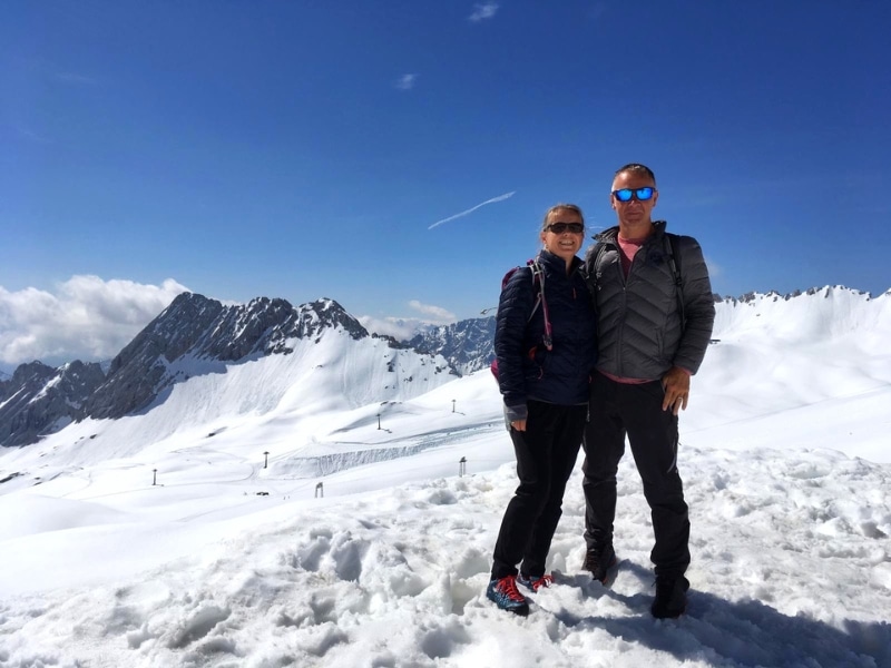 Couple in warm weather gear stading in a snowy landscape