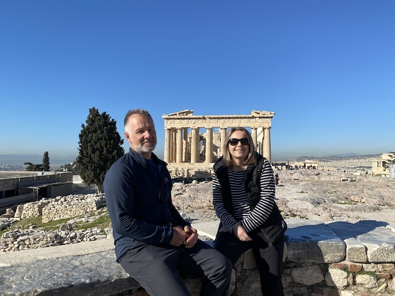 couple sitting on a wall at the Acropolis in Athens