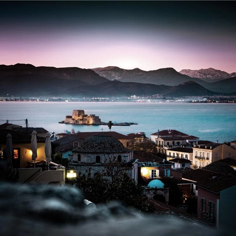 mountainous bay with a small castle on an island at night