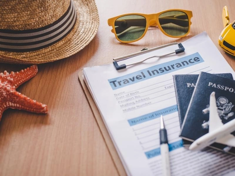 Travel insurance documents with passports and sunglasses