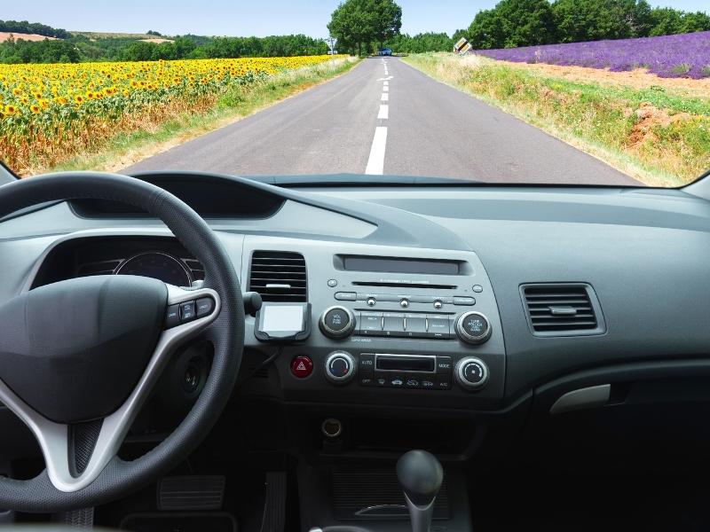 Car driving on a road in France through lavender and sunflowers