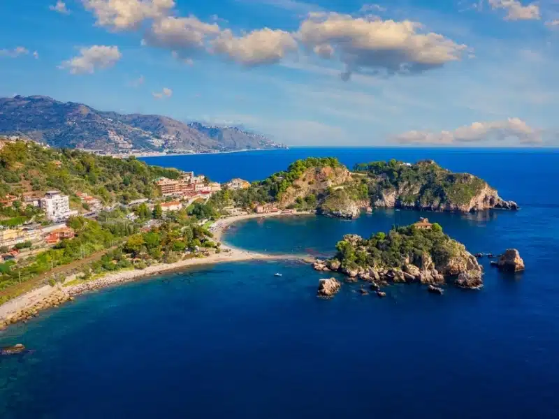 Isola Bella is small island near Taormina, Sicily, Italy. Narrow path connects island to mainland Taormina beach in azure waters of Ionian Sea.