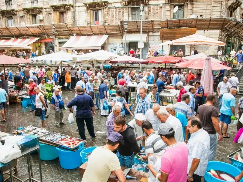 Sellers and buyers on the famous fish market in Catania on Sep 17, 2014, Italy. This market is also tourist attraction in Catania, Sicily.
