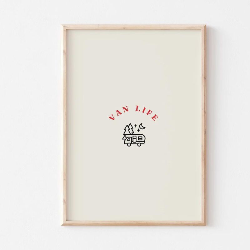 This images show an A4 print with a small drawing of a camper van with 2 small trees, a crescent moon and 2 small starts.  Above this in red letters it says Van Life.  IS has a cream background in a simple light wood frame.