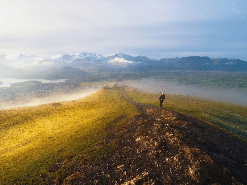 Group of hikers on grassy summit with amazing views