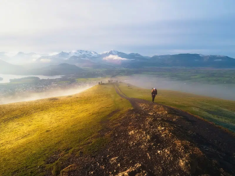 Group of hikers on grassy summit with amazing views