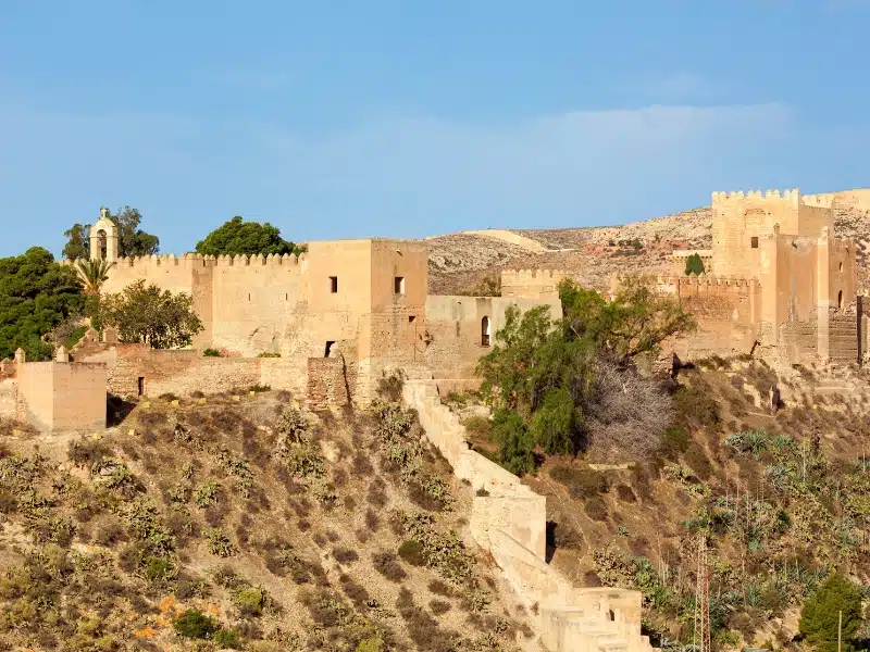 creamy stone fortified castle in a Moorish design built on a rocky hillside