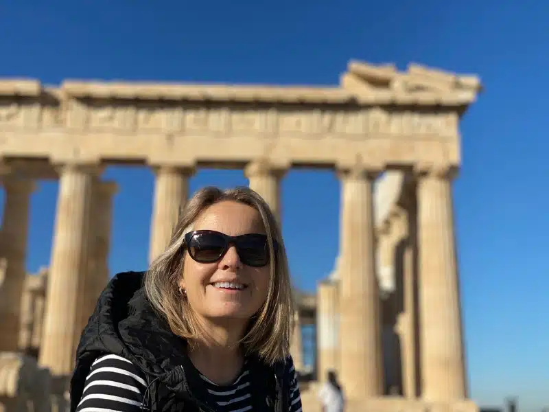 woman wearing sunglasses in front of an ancient temple in Athens