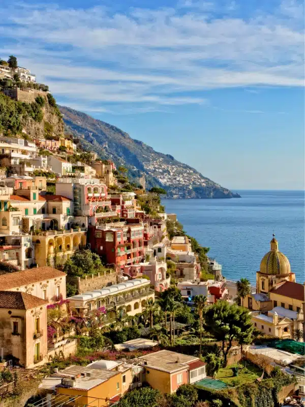 Colorful stacked houses and a domed church by the sea