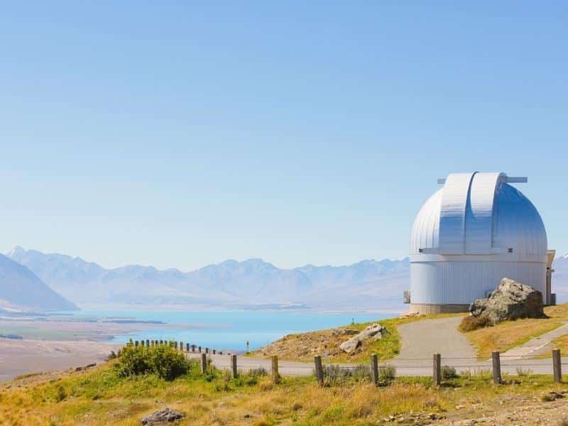 Silver observatory overlooking blue water and mountains