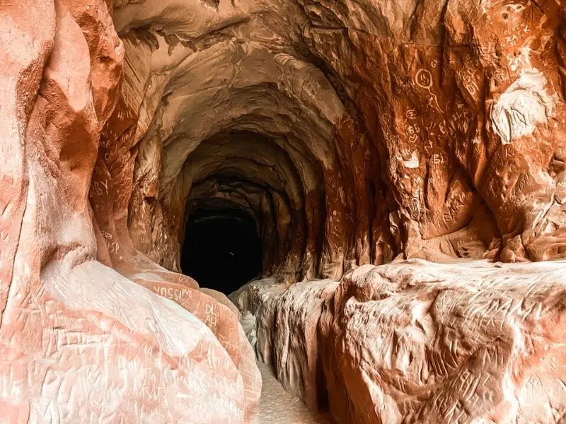 mouth of a sandstone cave with carved grafitti