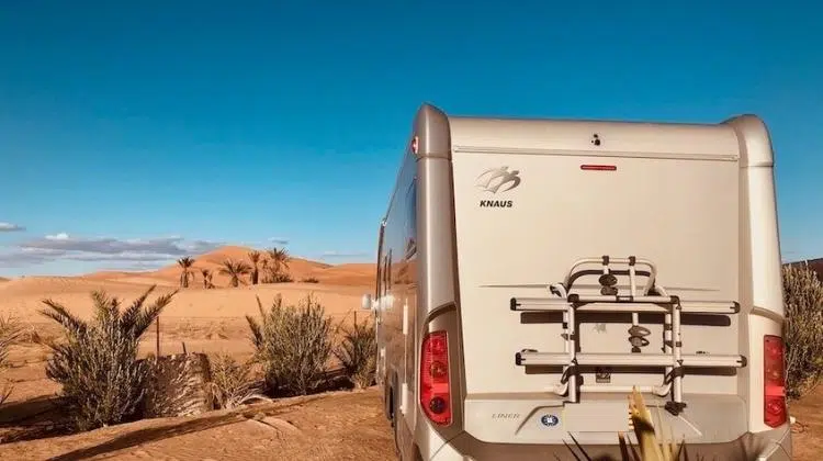 Motorhome parked in front of the dunes of Merzouga