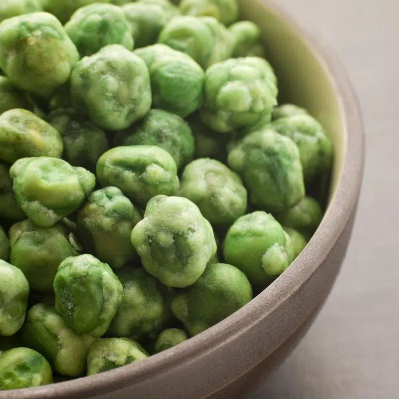 A bowl of green wasabi peas.