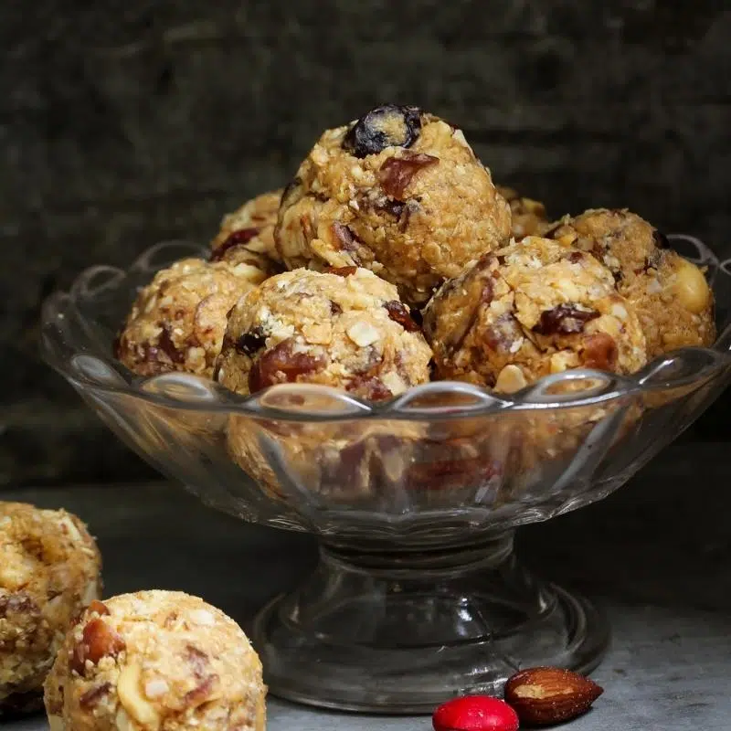 A glass bowl filled with cranberry protein balls.