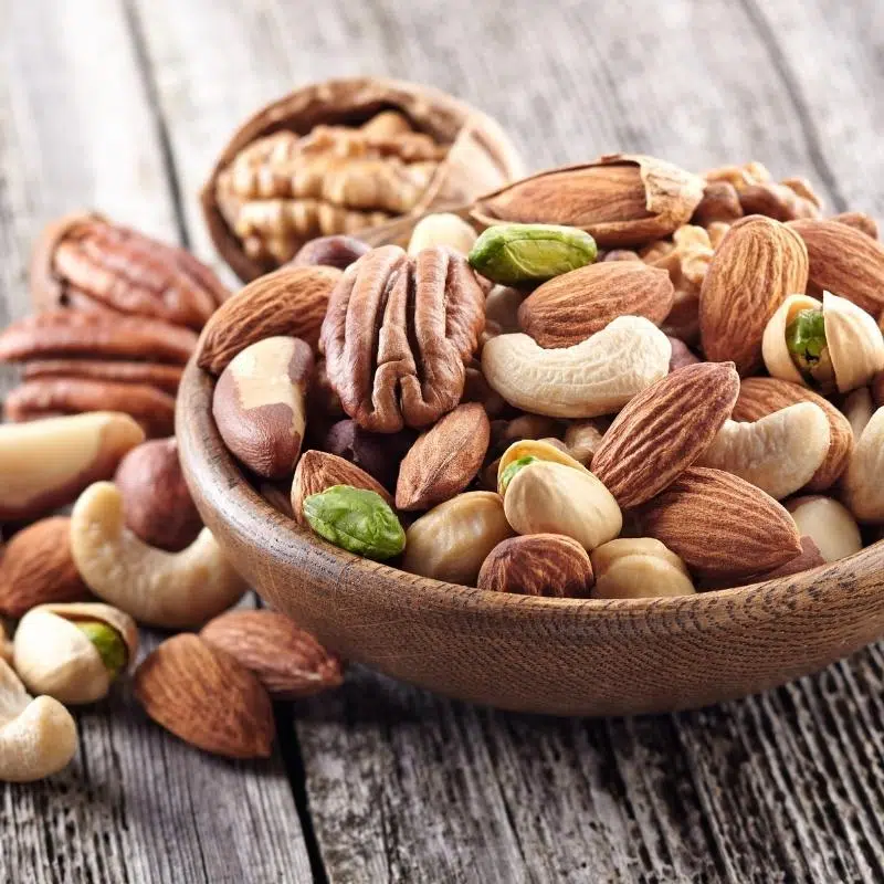 An image of mixed nuts in a wooden bowl.