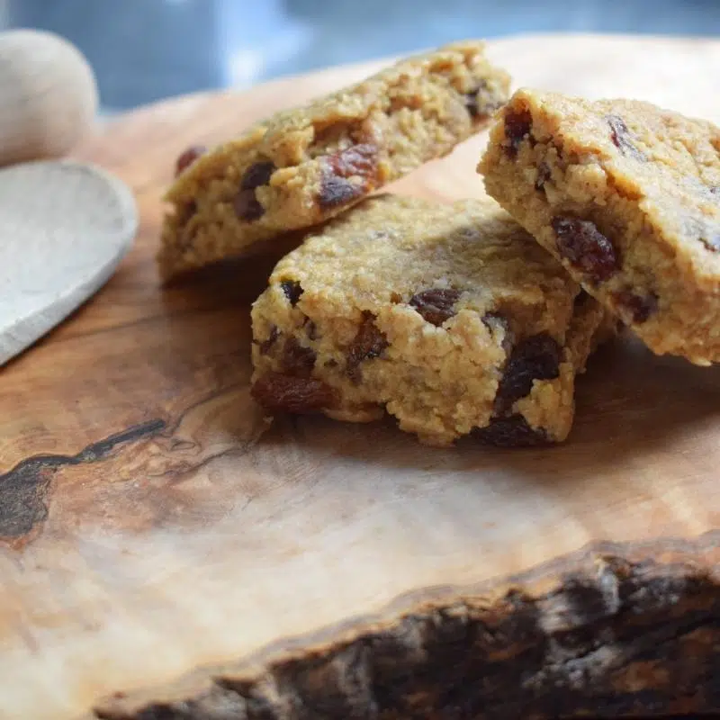 An image of three flapjacks on a wooden table.