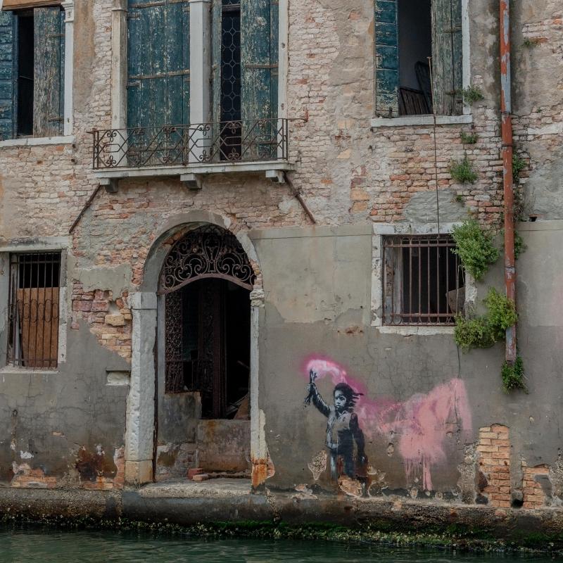 an image of the side of a canal with a pink and black and white girl, a stencilled work by Banksy