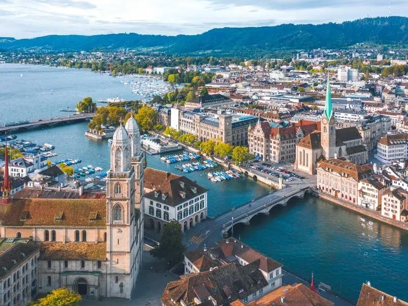 Aerial view of a lakeside city with a distinctive verdigris church spire