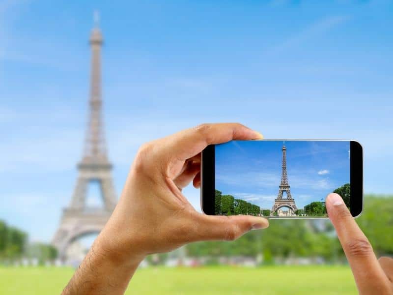 Person taking an image on an iPhone of the Eiffel Tower in Paris.