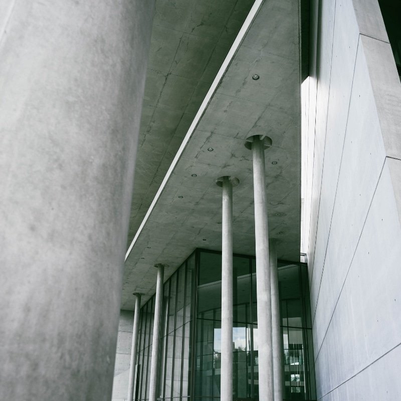 A close up image of the concrete columns and glass facade of the Museum of Modern Art