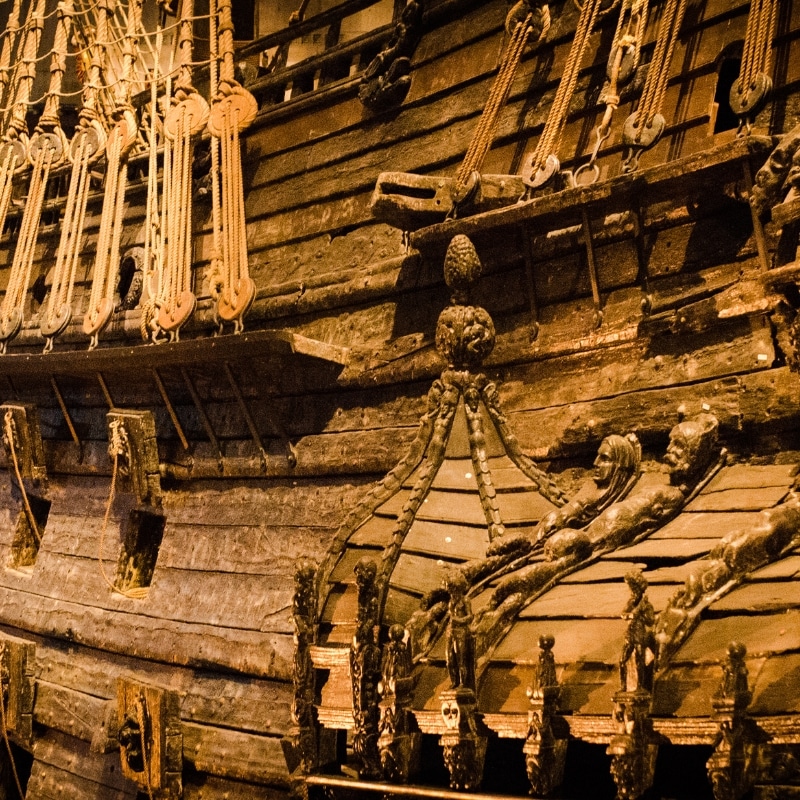 A close up image of the VASA warship, the image shows the side of the boat and the many wood sculptures adoring the boat.