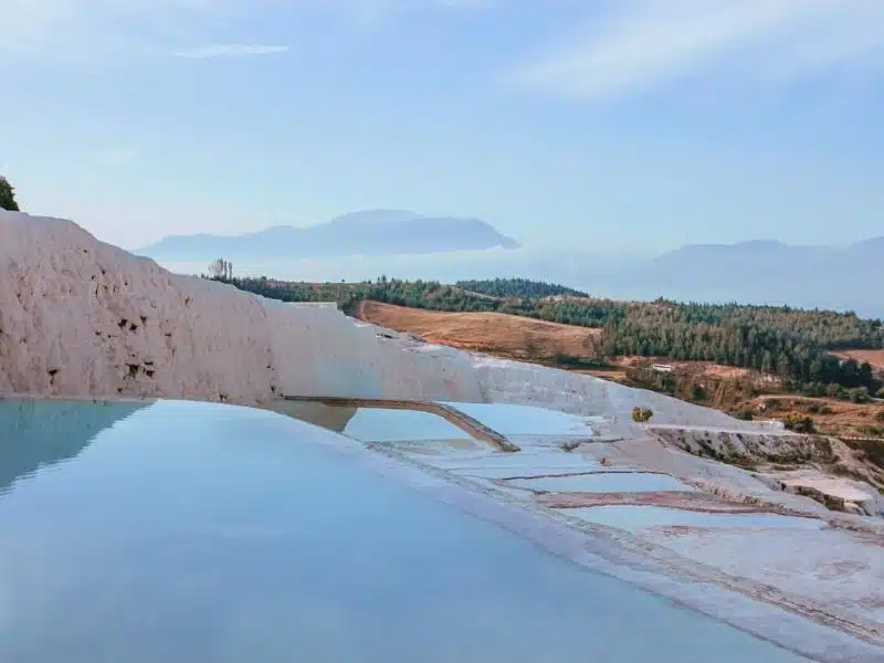 The pools of Pamukkale with forests in the distance
