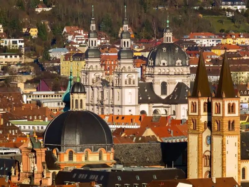 The skyline of a historic town, with domes churches, spires and teraccotta roofs.