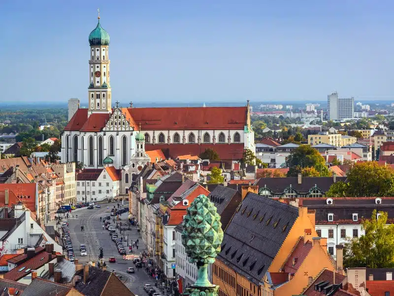 white Baroque church with spire nd verdis gris cuppola