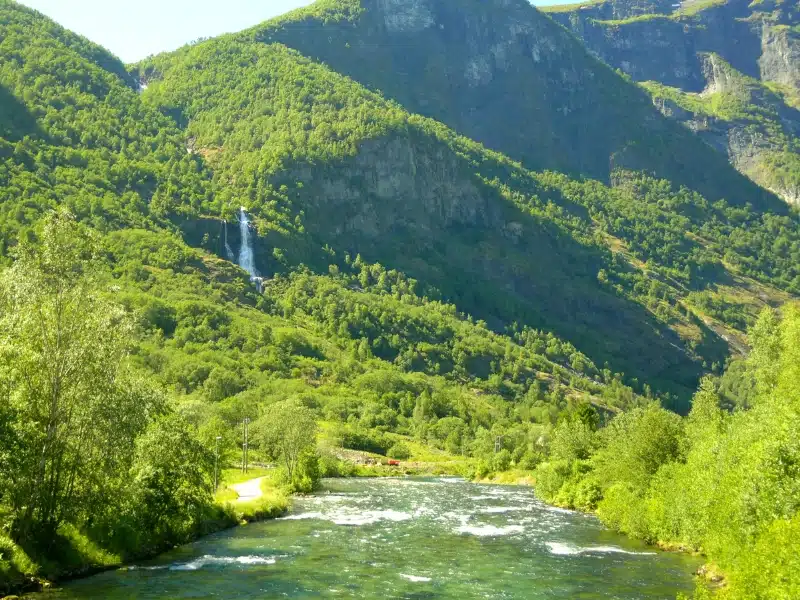 a large waterfall on a green mountainside