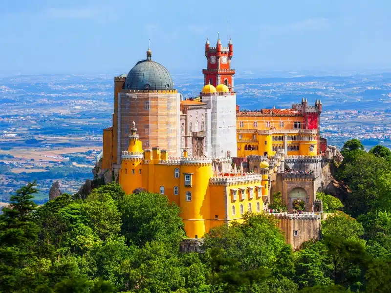 colourful building with towers turrets and a domed roof, painted in red and yellow