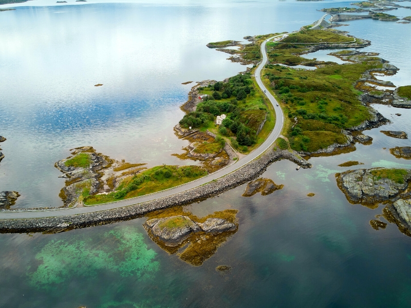 a tarmac road snaking between several islands surrouned by water