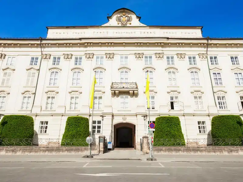 large cream stone building with yellow flags at the entrance