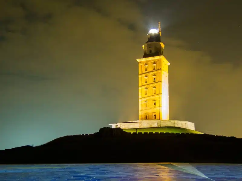 A large square lighthouse lit up at night