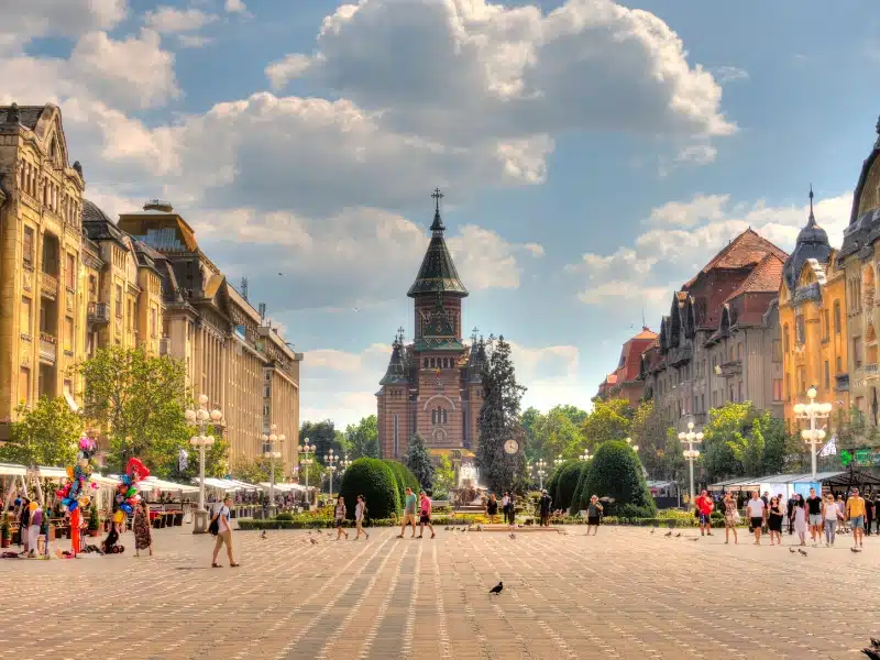 grand square lined with tall buildings and an ornate chuch on one side