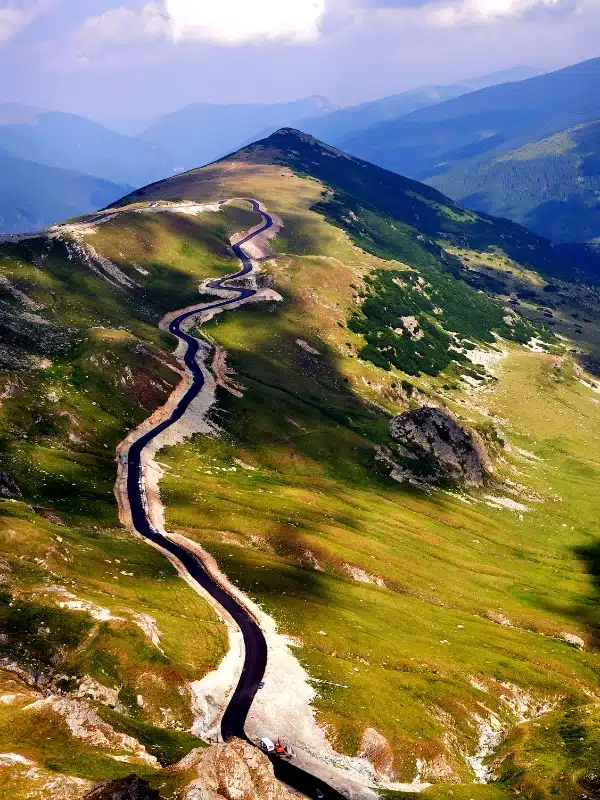 mountain road surrounded by rocks and grass