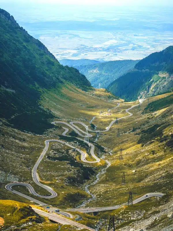 twisting road through a valley surrounded by big mountains