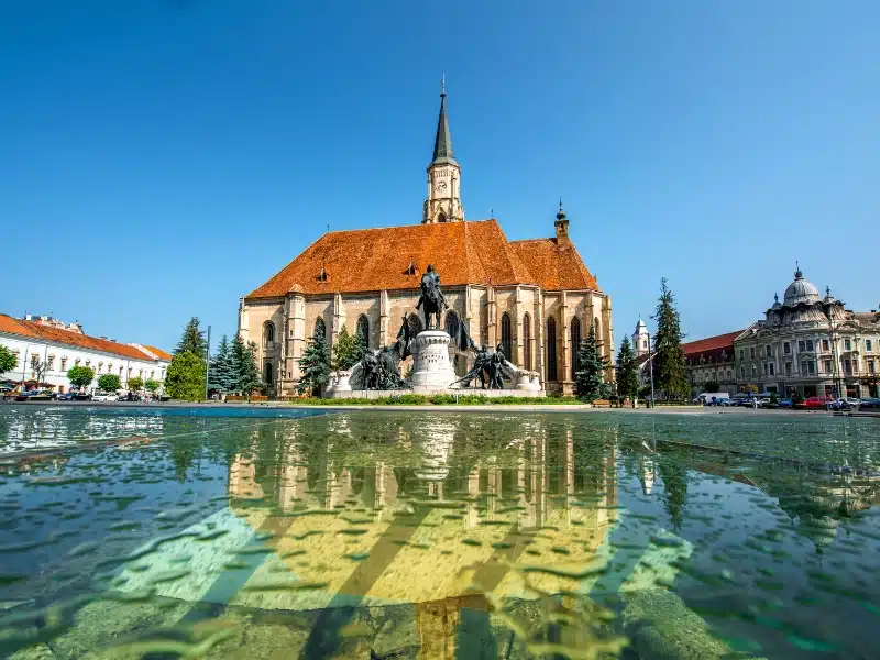Church and statue with a water filled pond in the foreground