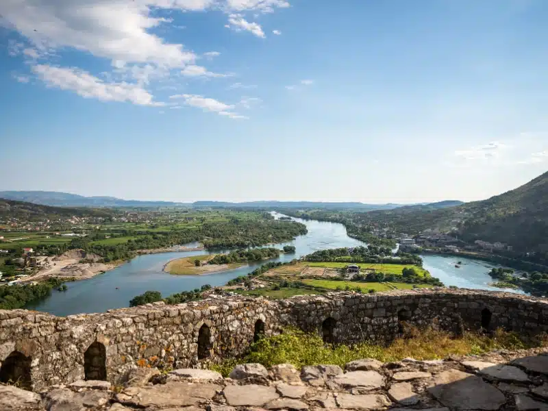 old castle wall with a  rive and fields beyond