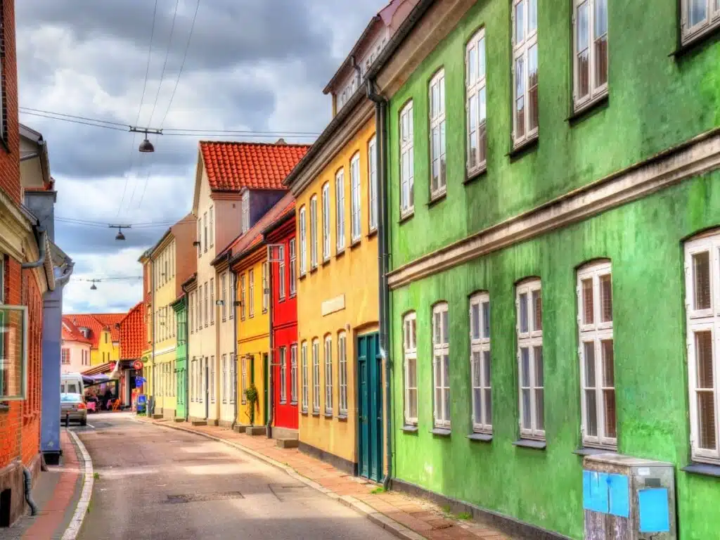 red, yellow and green houses lining a paved street