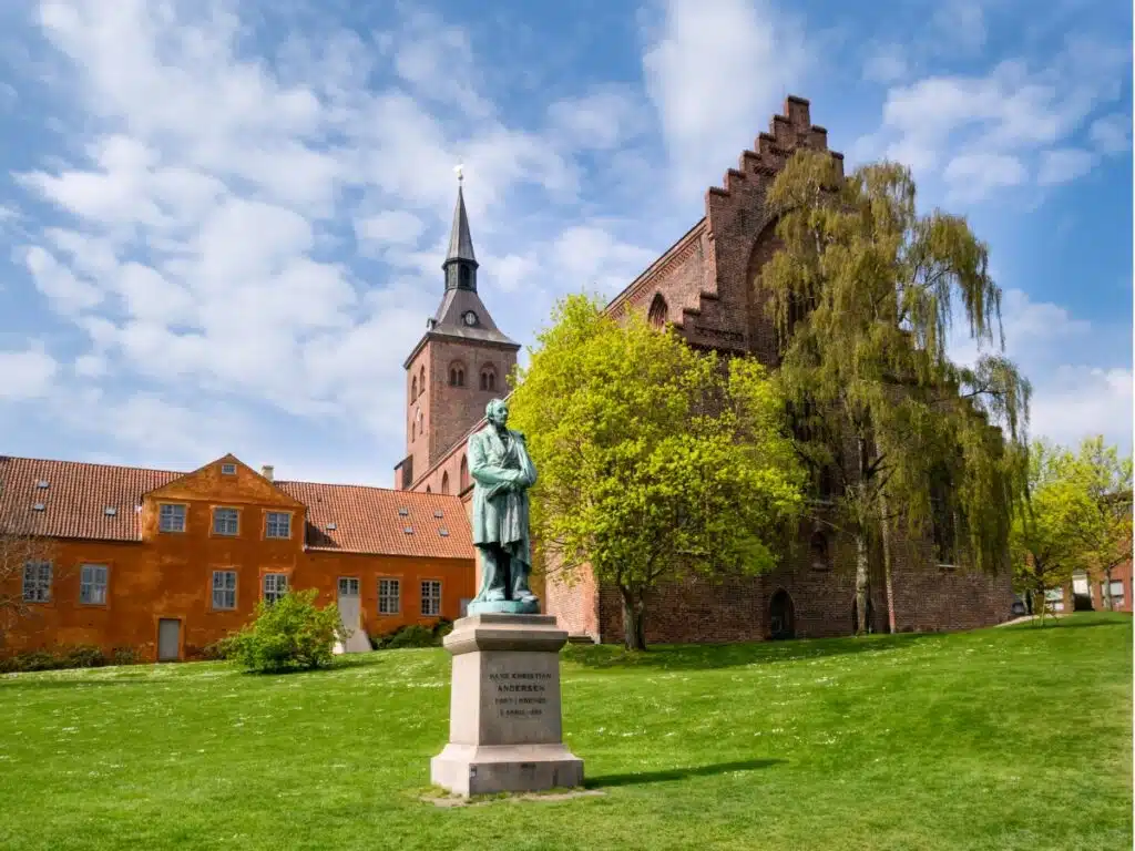 Statue of a man on a plinth in fromt of a church