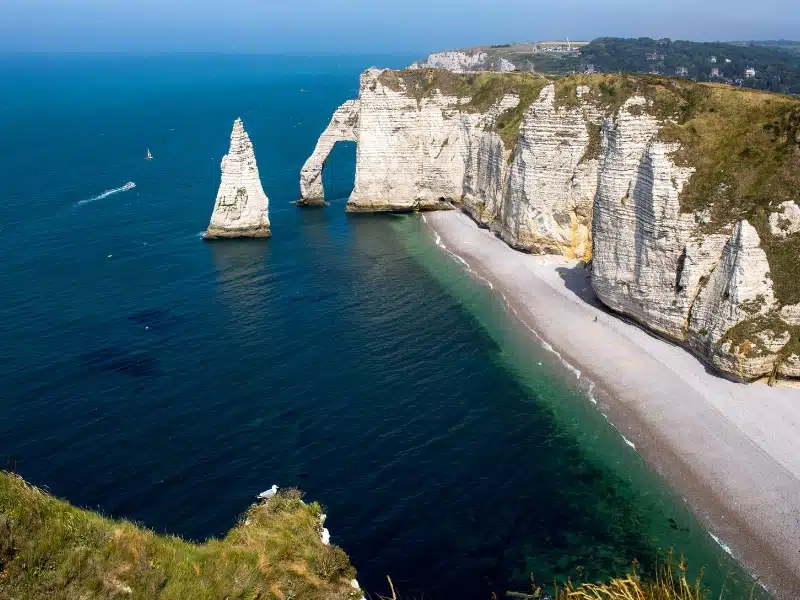 Rock arch and cliffs above a long sandy beach